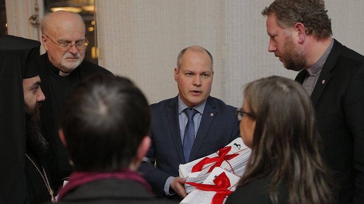 Kyrkoledarna lämnar över namnlistorna till Morgan Johansson. Foto: Natanael Johansson.