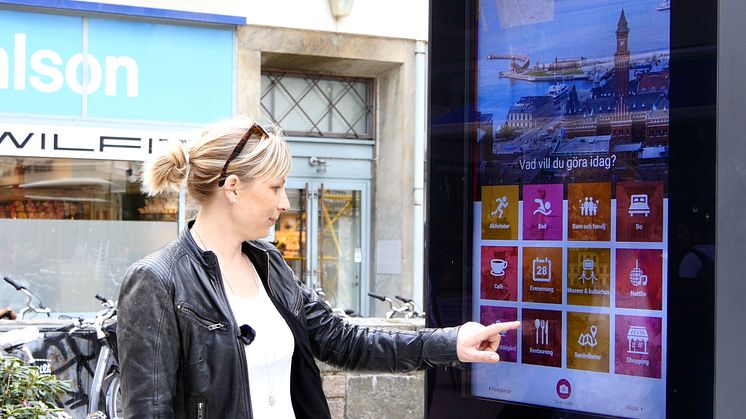 Emma Håkansson, turistchef i Helsingborgs stad, visar hur en infoskylt fungerar.