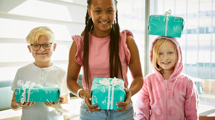 Melker, Elsa och Elias med inslagna paket. Fotograf Magnus Ragnvid