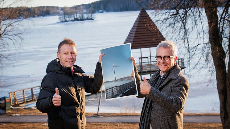 Jens Isemo och Bengt Storbacka med en visionsbild av det 150 meter höga vindkraftverket på Trallingen. Foto: Linde energi (bilden är ett montage)