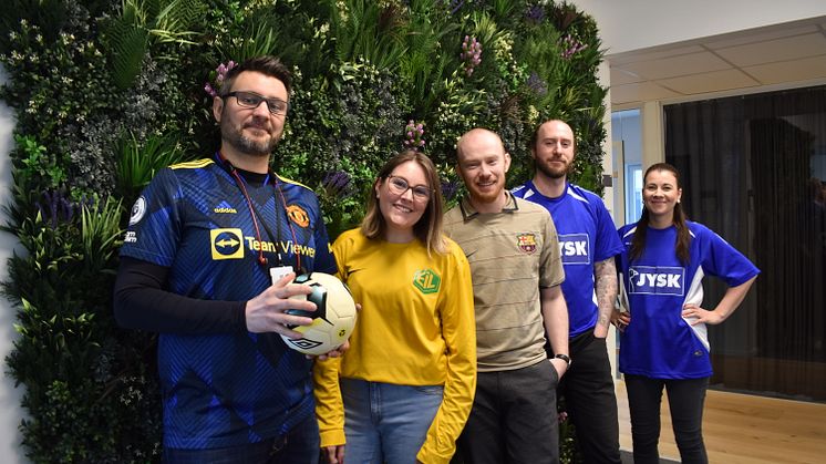 Ansatte i fotballtøy på jobb
