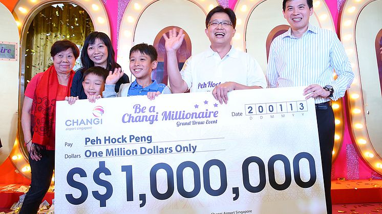 Mr Peh and his family receiving the S$1 million cheque from Mr Lee Seow Hiang, CEO of Changi Airport Group