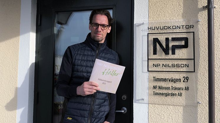 Hållbarhetschef Henrik Olandersson "håller" upp rapporten i tryckt form.