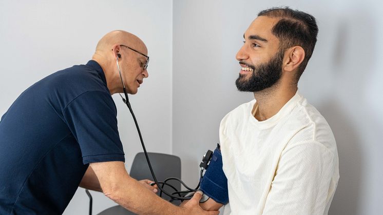 Christer Rosenberg, specialistläkare i allmänmedicin på Kvarterskliniken Karlastaden tar blodtrycket på en patient.