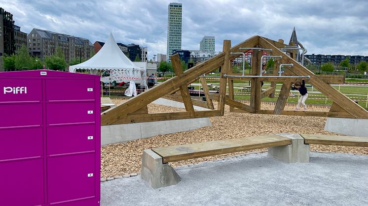 En rosa aktivitetsbox från Piffl är placerad vid en klätterställning i Hyllievångsparken i Malmö, där några barn leker i klätterställningen.