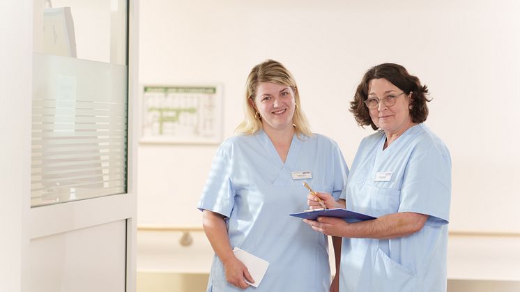 Die beiden Gesundheits- und Krankenpflegerinnen Katharina Boksgorn (links) und Carmen Weber im Stationsflur der Hephata-Klinik. (Foto: Hephata-Archiv/Stefan Betzler)