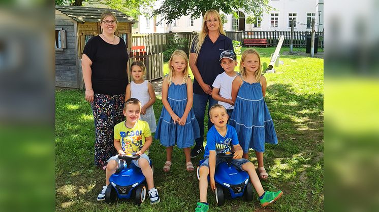 Kindergartenleiterin Rebecca Hinterecker (links) freute sich über die Spende, die Bayernwerk-Mitarbeiterin Karin Giehl (3.v.re.) überreichte. Elias und Korbinian testeten die blauen Flitzer gleich auf ihre Garten-Tauglichkeit.