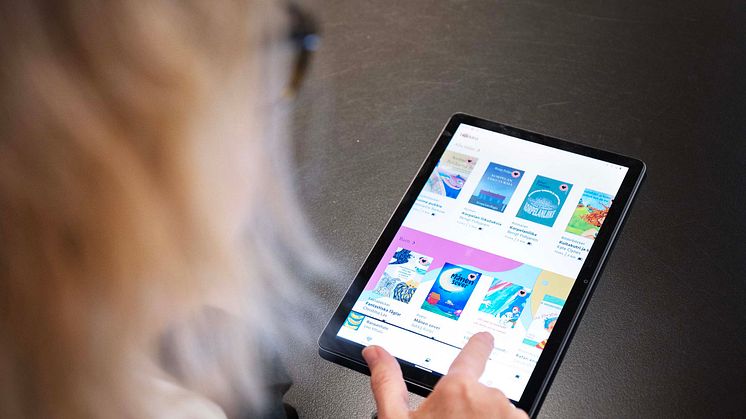 En kvinna syns bakifrån när hon scrollar i appen Bläddra på en Ipad.