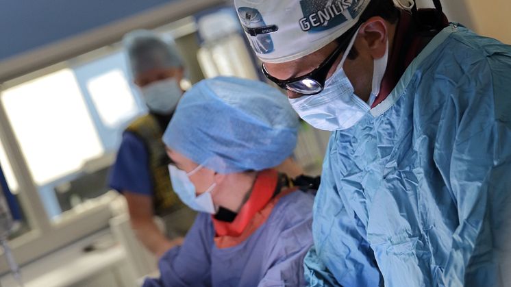 Doctor in scrubs performing thrombectomy procedure 