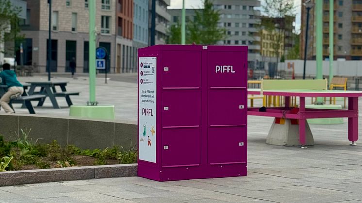 En rosa Piffl-box står på ett  torg. Runt omkring finns bordtennisbord, bänkar vilket skapar en aktivitetsyta.