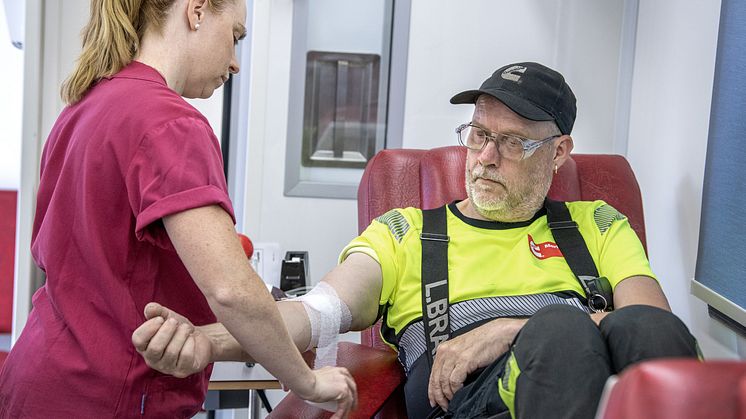 En personal sätter bandage på en blodgivare 