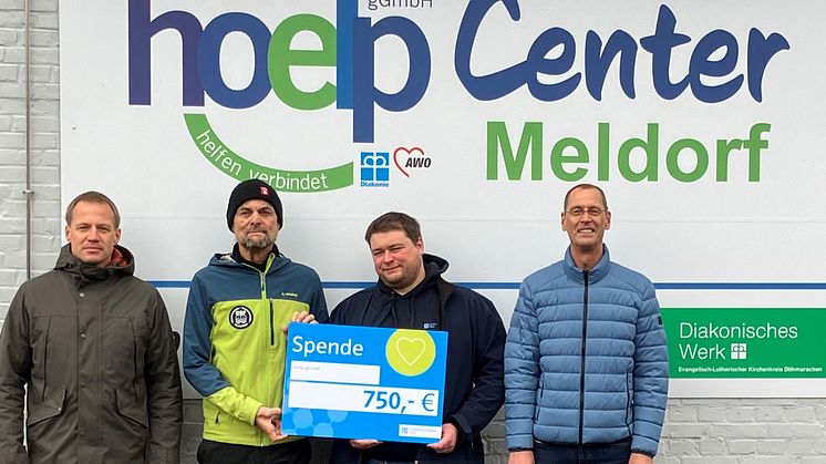 Tobias Dau (l.), Marc Hansen (2. v. r.) und Dirk Krause (r.) von Schleswig-Holstein Netz übergeben den Spendenscheck an Alexander Rose von der Hoelp gGmbH.