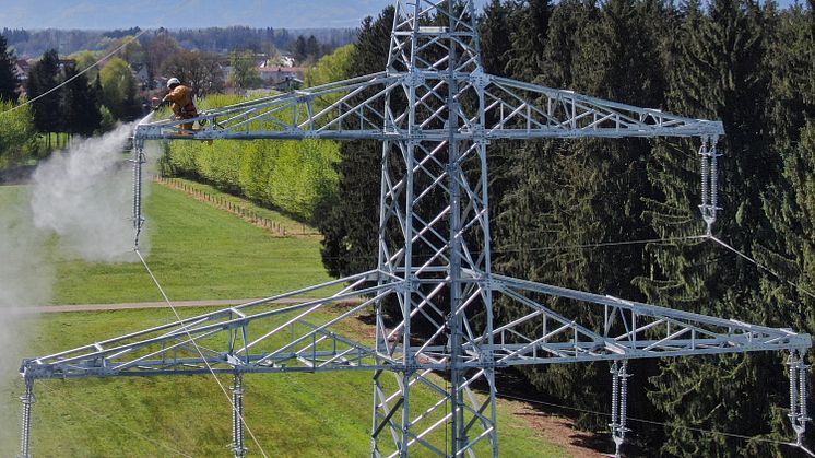 Mit dem Hochdruckreiniger werden die Masten der Hochspannungsleitung gereinigt, bevor sie einen frischen Anstrich erhalten - wie hier an einer Leitung im Landkreis Freising
