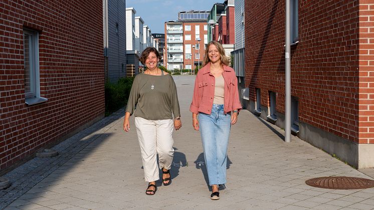 Två personer som går tillsammans sida vid sida. 