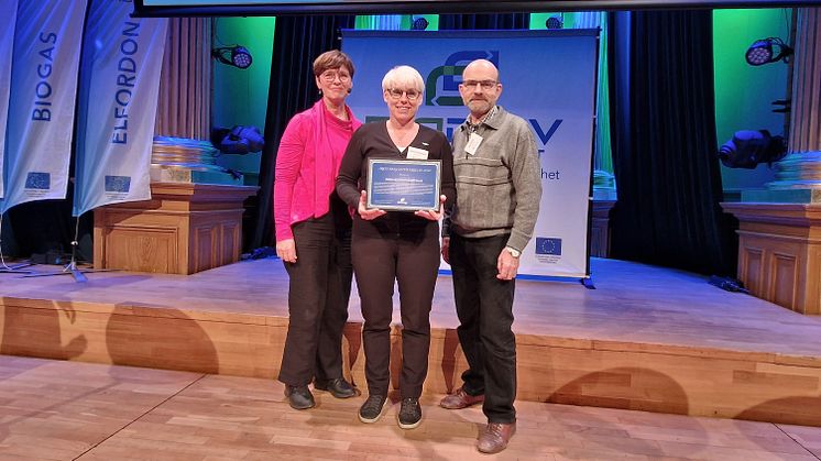 Ulrika Heie (C), ordförande Trafikutskottet (till vänster i bild) delar ut biogasutmärkelsen till Vafabmiljö Kommunalförbund. På plats för att motta priset var Sabine Dahlstedt, förbundsdirektör & Per Möller, vice ordförande.