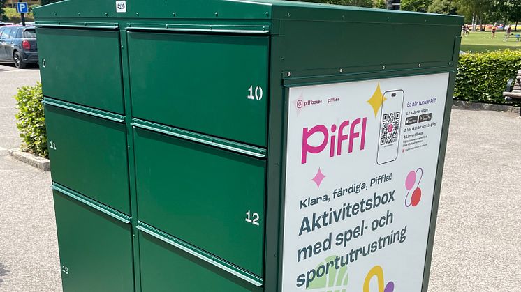 Grön aktivitetsbox från Piffl i Brunnsparken, Ronneby, placerad nära utomhusbadet och stora grön ytor.