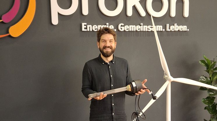 Christoph Teuchert mit einem der steuerbaren Heizstäbe, der in den Warmwasserspeicher einer Öl- oder Gasheizung eingebaut wird.