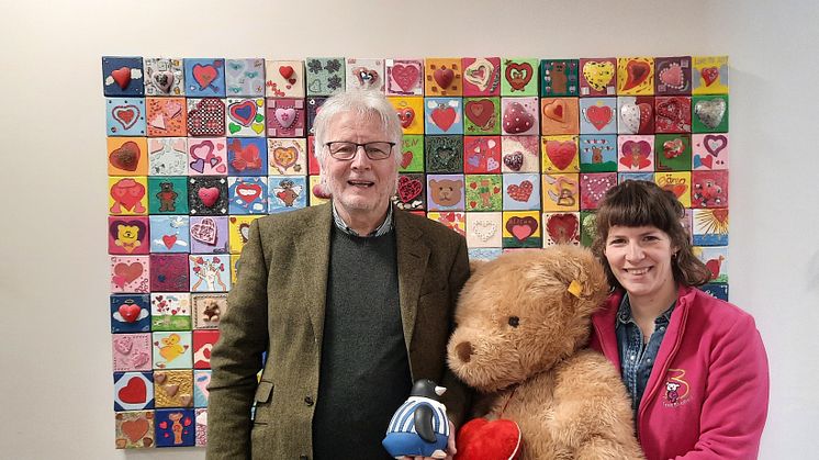 Dr. Wolfgang Höpken mit seiner gefüllten Pinguin-Spardose übergibt seine Spende an Melanie Müller (Bärenherz)