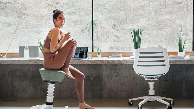 Eine Frau sitzt auf einem Bürostuhl Aeris Swopper.