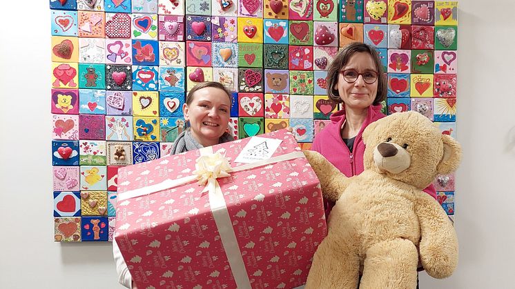 Frau Fleischer übergibt stolz ein großes Geschenkpaket an Anke Voigt (Bärenherz)