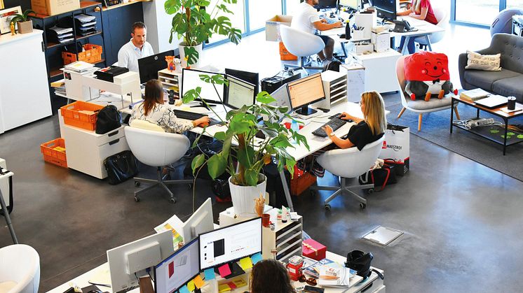 Kontorslandskap med anställda som arbetar digitalt i en trygg och stabil IT-miljö. 