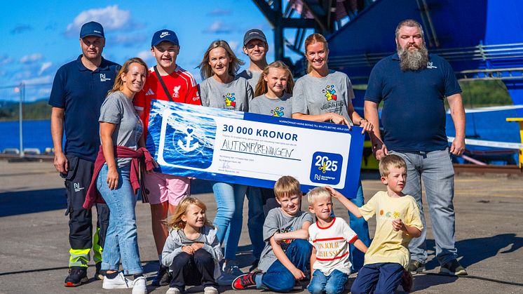 Familjer och barn från Autismföreningen tillsammans med två medarbetare från Norrköpings Hamn, visar upp priset.