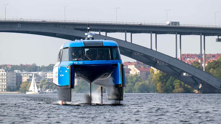 Candela P-12 'Nova' flyger på Riddarfjärden med Västerbron i bakgrunden, på väg från Ekerö till Stockholms stadshus.