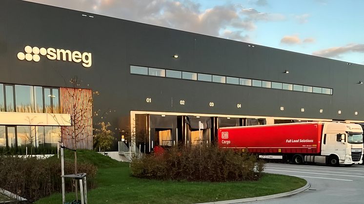 Utanför Smegs lager syns DB Cargo Full Load Solutions röda trailer rulla in med gods för lossning. Godset transporteras via DB Cargo Full Load Solutions intermodala transportlinje mellan Sverige och Italien.