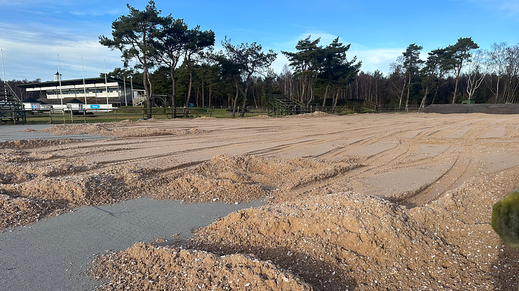 Den nya fibersanden installeras, här på framridningen till Internationella Hopparenan