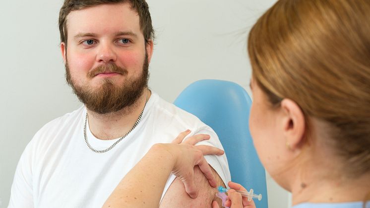 Ung man som får vaccin.