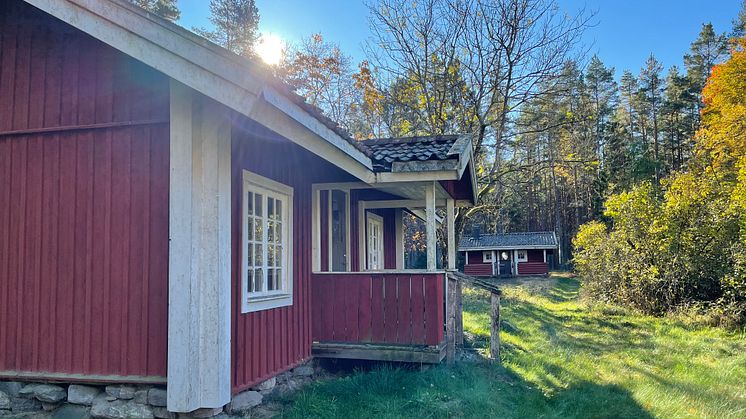 Två röda stugor med vita knutar.