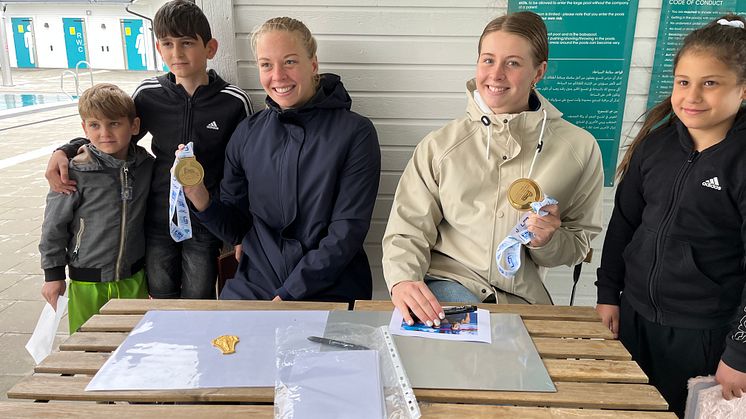 Syskonen Hussein, Batoul och Adam, glada deltagare i sommarsimskolan, träffar sina idoler Louise och Sophie för autografer.