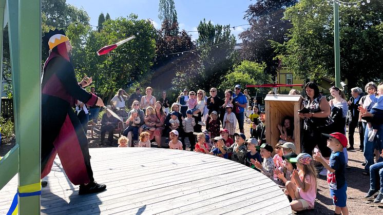 Man på scen jonglerar framför en publik av barn och vuxna.