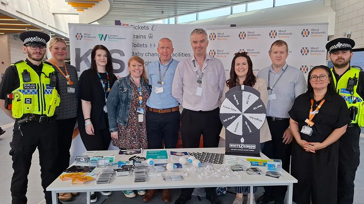 Members of BTP, WMR and Rethink Mental Illness stand in Wolverhampton station, behind a table of safety-related items