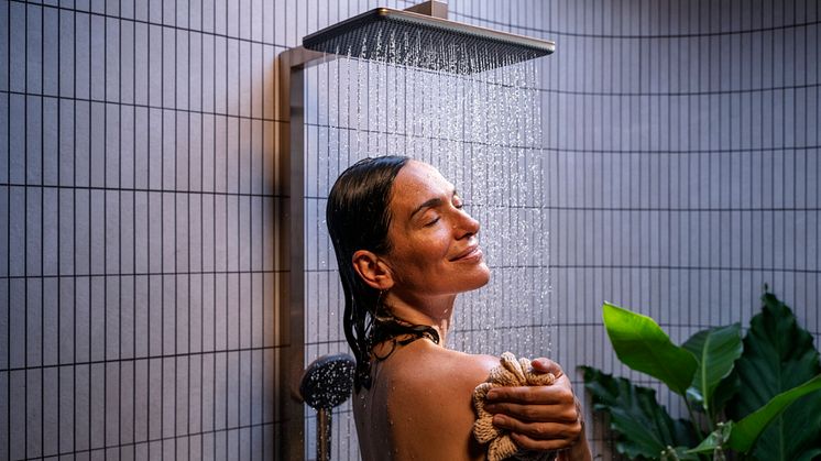 Kvinde nyder brusebadet under en hansgrohe Raindance Alive bruser.