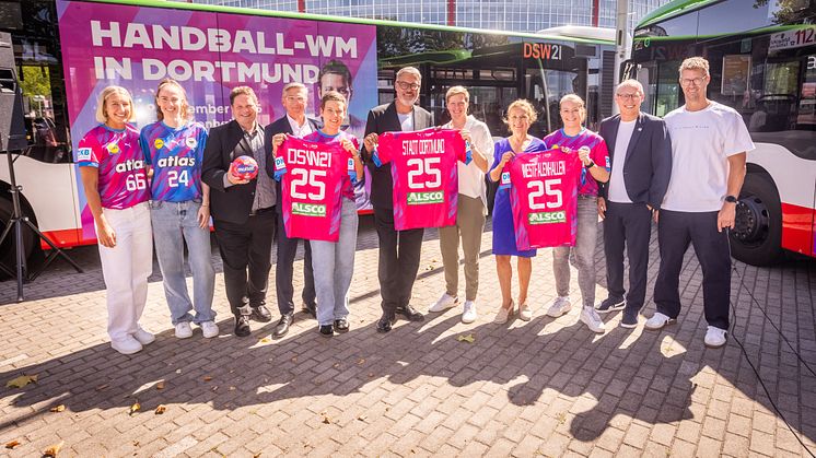 Spielerinnen und Offizielle vor einem der Werbebusse