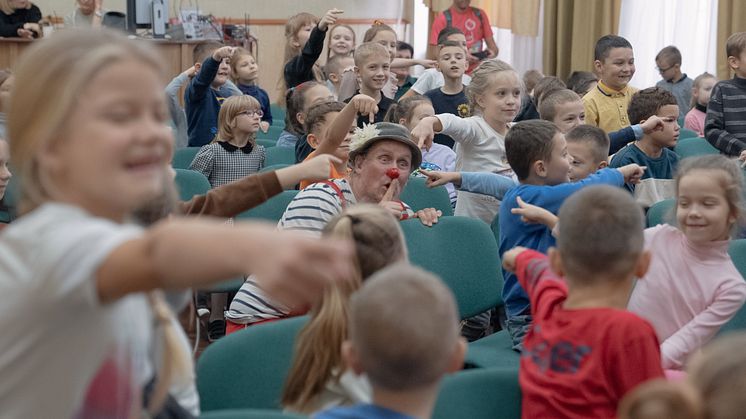 Foto från en tidigare turné till Ukraina 2023. Ukrainska barn leker Kurragömma tillsammans med artisten Jonas Sjögren. 