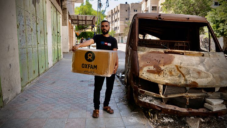 Raed Mansour håller i ett matpaket från Oxfam som delas ut bland fördrivna människor i Gaza City. Foto: Alef Multimedia/Oxfam