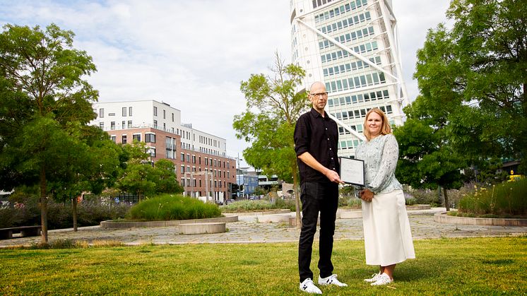 Anders Sjöholm, arbetskonsulent vid Malmö stad, överräcker ett intyg till Maria Nilsson, hållbarhetschef på HSB Malmö.