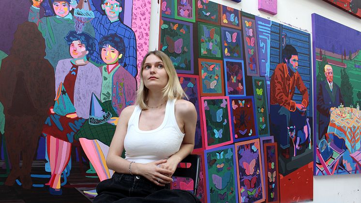 Die Künstlerin Zoe Klink vor ihren Werken, inklusive „Dead Or Alive“, eine ihrer am ARTIMA Messestand ausgestellten Arbeiten