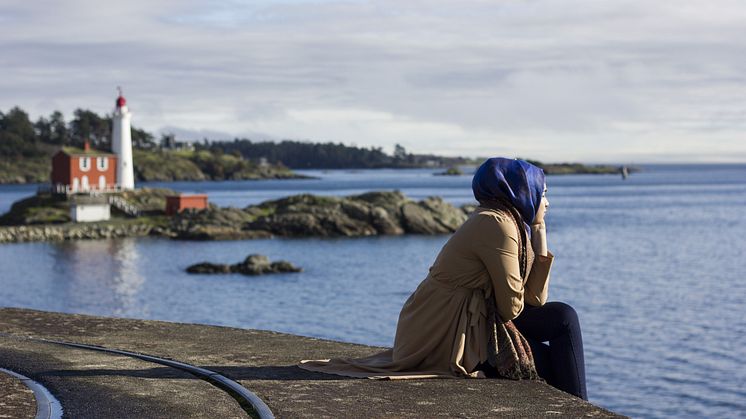 Ung kvinna med hijab blickar ut över en sjö.jpeg