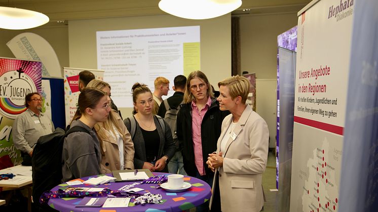 Am Info-Stand der Hephata Diakonie informieren sich Studierende bei Anja Krebs über Praxisstellen in der Jugendhilfe. 