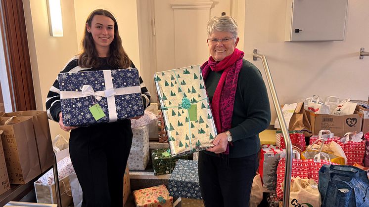Katharina Hollendung, Trainee bei Deutsche Glasfaser, übergibt Geschenke an Hanne Watty von der Benrather Tüte.