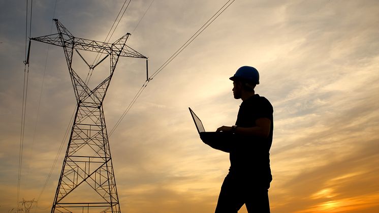 silhouette-of-electrical-engineer-on-laptop-computer-inspecting-transmission-tower-at-sunset-getty-637589830.jpg