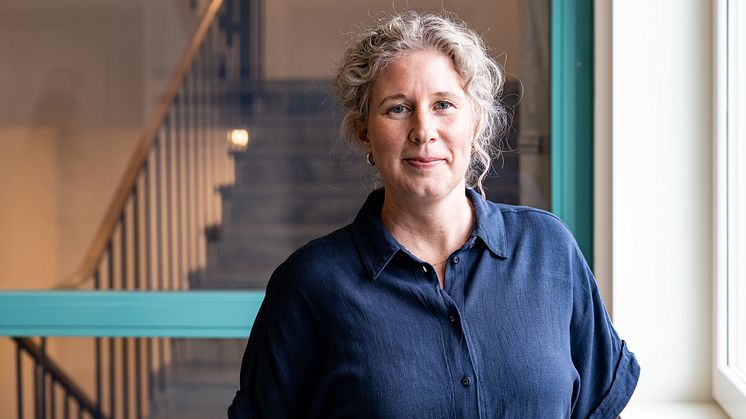 Porträttbild av en person med ett trapphus i bakgrunden.