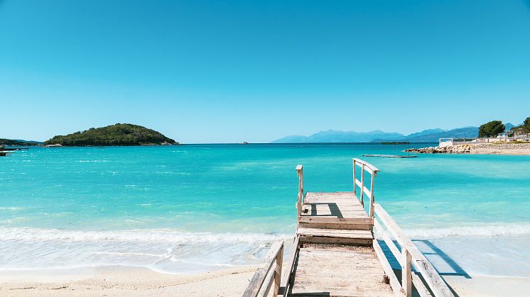 Rimelige feriedestinasjoner som også tilbyr kritthvite strender og turkist vann. Foto av nasjonalparken Ksamil i Albania. 