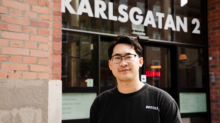 Konstnären Sai framför entrén till Karlsgatan 2.
