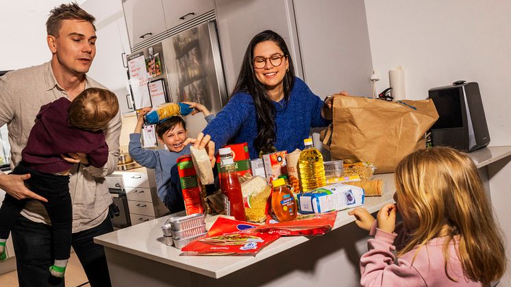 En familj packar upp matvaror som ska placeras i krislådan. 