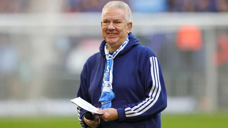 Auf dem Bild ist der bisherige Stadionsprecher Dirk Oberschulte-Beckmann mit Mikro und Moderationskarten zu sehen