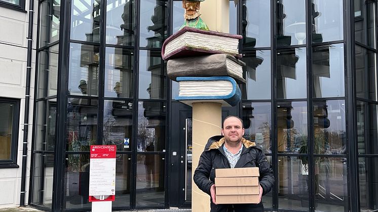 Berat Meholli, Informationssäkerhets- och dataskyddssamordnare på LKF, överlämnar styrelseprotokoll till stadsarkivet